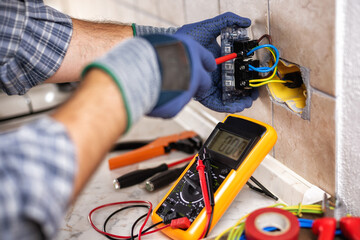 Electrician at work with safety equipment on a residential electrical system. Electricity.
