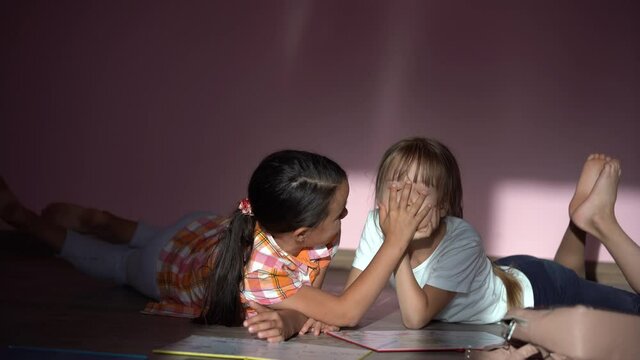 Adorable little girls study at home with books, girls playing together, drawing, doing homework at home. friends having fun learning