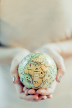 Girl holding in her hands a little globe in retro style