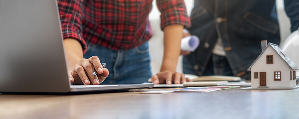 Interior designer and Architect choosing color in color swatch samples chart for house coloring selection in office with blueprint. Construction concept.