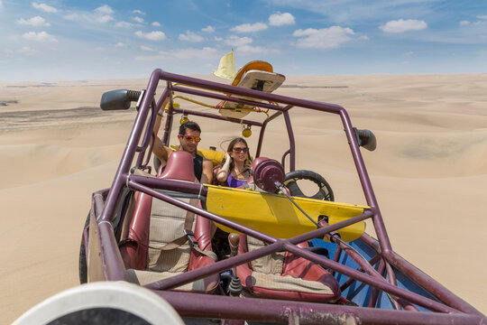Young couple preparing to ride a dune buggy