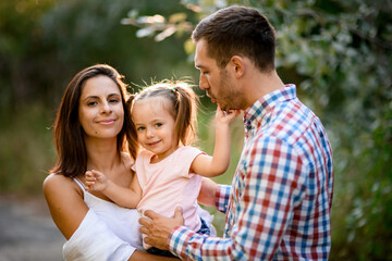 portrait of handsome family couple with little cute daughter