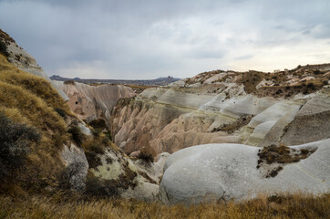 Naklejka premium Natural valley with volcanic tuff stone rocks in Goreme in Cappadocia, Central Anatolia region of Turkey. Popular tourist destination in Turkey for trekking.