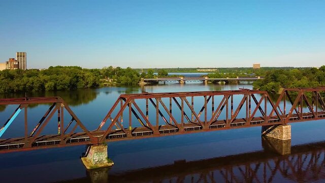 A beautiful and peaceful drone shot of the river as we fly over an old train bridge.