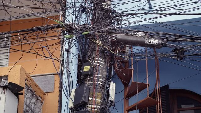 Crowded power lines in a messy junction of wires in a typical slam scene. Poetry in the poor neighbourhood chaos.