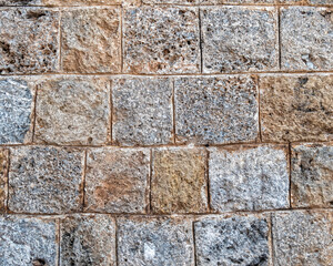 regular cut stone wall closeup, natural textured background
