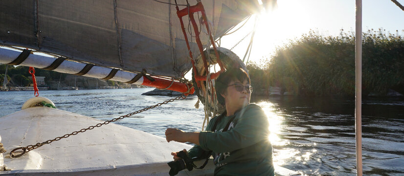 Aswan Egypt Asian tourist photograph felucca at Nile river beautiful histoical vacation trip