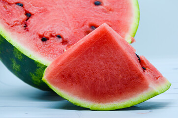 Close-up of triangular piece of watermelon and cut in half a watermelon on white background. Ripe...