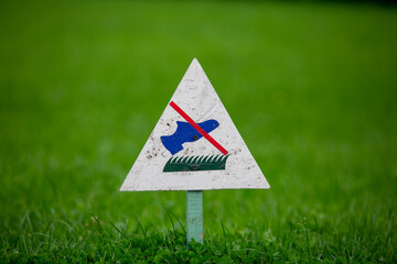Signpost on the lawn does not walk on a background of lush green grass. close-up. copy space