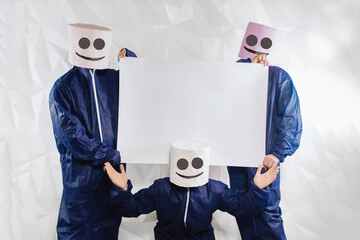 Three men in a suit of a marshmallow man on a white structural background hold a banner for your...