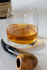 Isolated alcoholic drink, aged cognac and cigar pipe