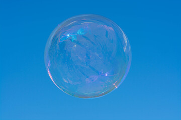bright transparent soap bubble with a shimmering flying over a Sunny summer meadow