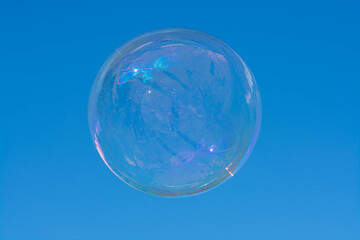 bright transparent soap bubble with a shimmering flying over a Sunny summer meadow