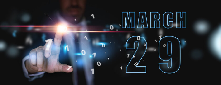 march 29th. Day 29 of month,advertising or high-tech calendar, man in suit presses bright virtual button spring month, day of the year concept