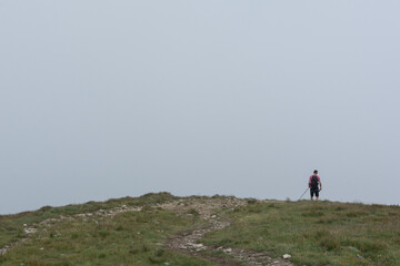 man with trekking sticks walking in the mountains