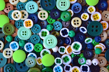 Fototapeta na wymiar Aerial view of many multi-colored buttons on a wooden table