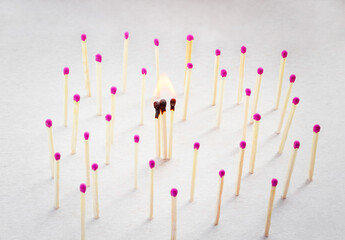 three matches nearby are burning, matches in the distance are whole