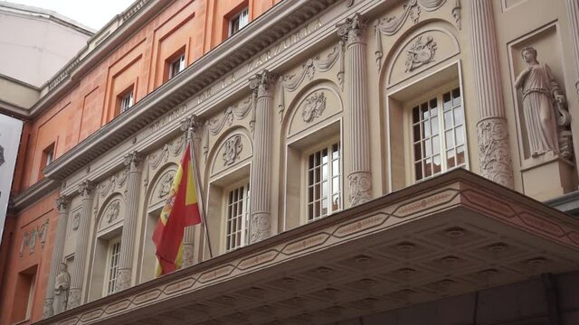 Static shot of Spanish flag flying outside Teatro de la Zarzuela in Madrid, Spain