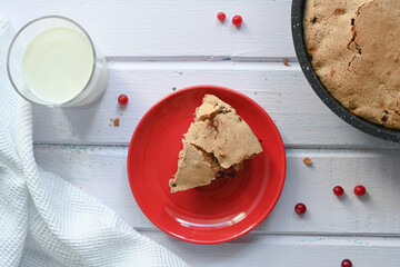 Charlotte with cranberries on a white wooden background