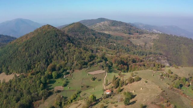 Drone flight over an autumn mountain with peaks, meadows and colorful forests, Balkan mountains, Bulgaria
