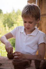 The child makes dishes and various figures from clay. Pottery skills. Hobbies and interests. Children's education, expanding horizons.