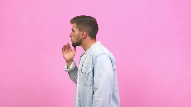 Young caucasian handsome man whispering gossip undertone, trying not to be heard