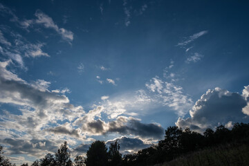 Beautiful clouds in contour sunlight against a dark blue sky.