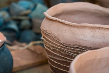 In the pottery shop, the sun's rays fall on the pottery. A clay pot and a jug. The natural pattern on the clay. Background, texture.
