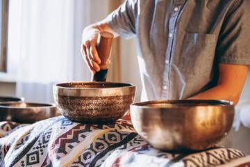 man holding and playing a singing bowl tibetan bowl