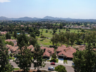 Aerial view of middle class neighborhood with residential house community and mountain on the background in San Diego, South California, USA.