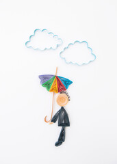 A man with colored umbrella under the clouds. Hand made of paper quilling technique.