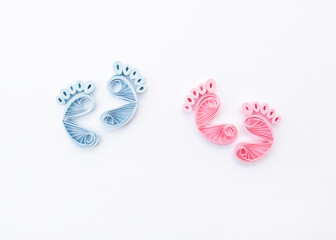 Fototapeta premium Cute baby boys and girls footprints. Traces of children on white background. Baby footsteps. Hand made of paper quilling technique.