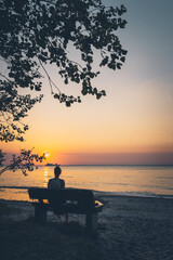 Fototapeta na wymiar Frau genießt den Sonnenuntergang an der Ostsee