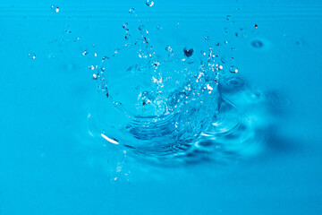 Fototapeta na wymiar splash of water on a blue background. Abstract wallpaper