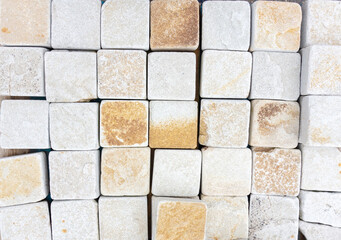 White background from natural stone paving stones. Texture with white stone squares. Paving garden paths and sidewalks with natural stone tiles.