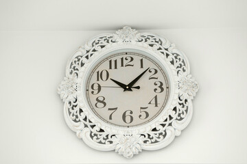 old vintage white clock on white wall.