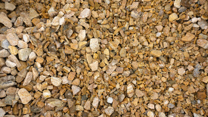 Natural crumb of goldstone or zlatolite for a stone background. Texture of orange, sand and brown pebbles. Stone chips for landscaping, rockeries, rock gardens, garden paths, mixborders.