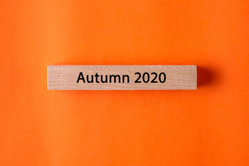 Wooden plaque with an inscription on a bright orange background. Time for study, new business projects and inspiration. Autumn mood and the month of fall 2020. Free space for text.