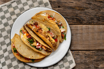 Mexican hard-shell tacos with meat and fresh sauce on wooden background