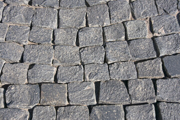 Texture of gray vintage natural urban paving stone close up
