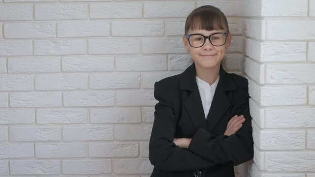Child manager in business corporation. A view of a nice smiling teen manager in the costume in the room.