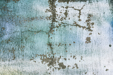 Texture of old blue painted building wall with cracks and smudges close up