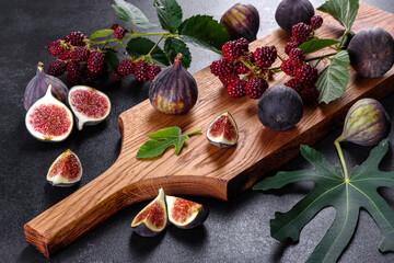 Fresh juicy figs and blackberries on a dark background