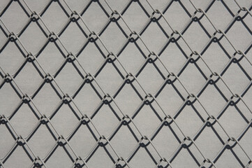 Fototapeta premium Texture of gray metal lattice on gray background close up