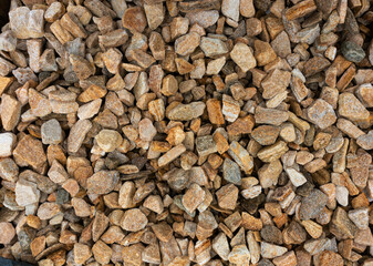 Stone chips from natural sandstone and goldstone. Background from orange and brown stones. Texture of small stones. Zlotolite for garden paths, flower beds and borders
