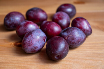 Purple plums on a wooden table