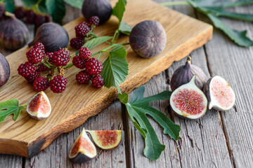 Fresh juicy figs and blackberries on a dark background
