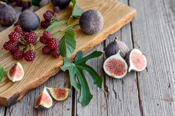 Fresh juicy figs and blackberries on a dark background