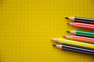 banner for school. colored pencils lie on a notebook. teaching at school. school supplies