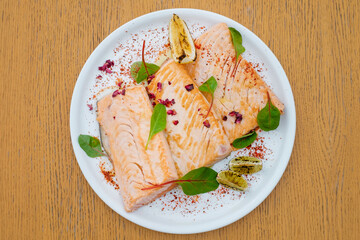 Grilled fish garnished with lemon and basil top view.  Decorated catering banquet menu with different food snacks and appetizers with sandwich.